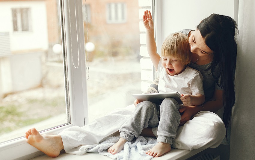 Mother and little son sitting on a windowsill